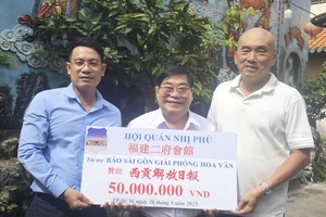 福建二府会馆理事长彭伟强（中）、理事赖学良（右一）已向本报领导移交5000万元。