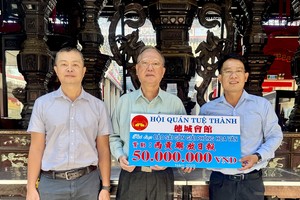 穗城会馆理事长卢耀南（中）与理事梁锦权（左）向《西贡解放报》执行编辑文忠孝（右）移交赞助经费。