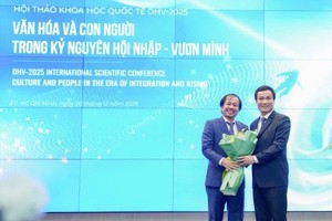 雄王大学校务委员会常务副主席、副校长陈越英博士（左）向国会文化、教育委员会副主任、副教授、博士赵世雄赠送鲜花。