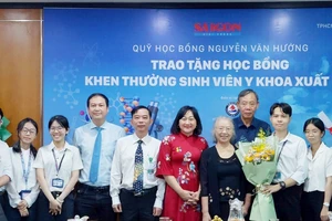 Ban tổ chức chụp ảnh lưu niệm cùng sinh viên nhận học bổng. Ảnh: VIỆT NGA