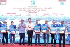 Nguyên Phó Thủ tướng Thường trực Chính phủ Trương Hòa Bình và Phó Chủ tịch UBND TP Đà Nẵng Trần Chí Cường trao quà tặng cho ngư dân. Ảnh: XUÂN QUỲNH