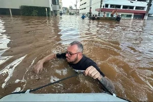 Người dân thành phố Porto Alegre vượt lũ. Ảnh: The Guardian