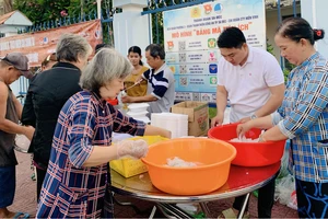 Anh Ngô Văn Quí (thứ 2 từ phải sang) chuẩn bị những suất ăn 0 đồng trao đến người nghèo