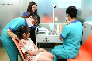 Nhân viên y tế tiêm vaccine cho trẻ