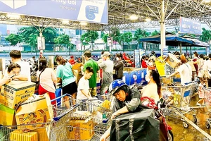 Người dân chờ đóng gói thực phẩm tại siêu thị MM Mega Market Hiệp Phú, quận 12, TPHCM. Ảnh: NGUYỄN TRUNG