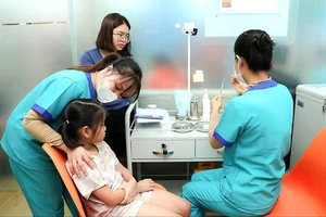 Nhân viên Trung tâm tiêm chủng Long Châu đang tiêm vaccine cho trẻ