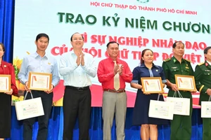 Phó Bí thư Thường trực Thành ủy TPHCM Nguyễn Hồ Hải trao Kỷ niệm chương Vì sự nghiệp nhân đạo của Hội Chữ thập đỏ Việt Nam đến các cá nhân. Ảnh VIỆT DŨNG