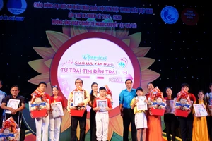 Phó Chủ tịch Hội Chữ thập đỏ TPHCM Trần Văn Tuấn và Phó Chủ tịch Thường trực Hội Liên hiệp Thanh niên Việt Nam TPHCM Doãn Trường Quang tặng quà và thư cảm ơn các đơn vị tham gia chương trình. Ảnh: THÚY BÌNH