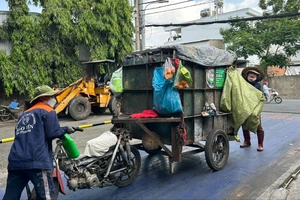 Người thu gom rác dân lập cân tại trạm cân ở xã Bà Điểm, huyện Hóc Môn. Ảnh: THANH HIỀN