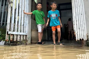 Nước dâng cao, tràn vào tận hiên nhà các hộ dân đường Mẹ Suốt. Ảnh: PHẠM NGA