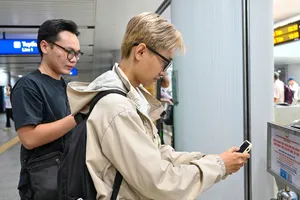 Hành khách di chuyển bằng metro ủng hộ đồng bào bị ảnh hưởng do mưa lũ thông qua các điểm bố trí QR code ủng hộ. Ảnh: MẠNH THẮNG