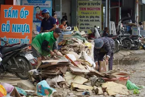Người dân phường Tây Nha Trang (tỉnh Khánh Hòa) dọn dẹp rác tồn đọng sau trận lũ lịch sử. Ảnh: HIẾU GIANG