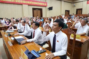 Các đại biểu biểu quyết thông qua Nghị quyết tại kỳ họp. Ảnh: NAM KHÔI