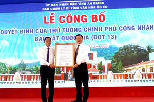 Ông Nguyễn Khánh Hiệp (bên trái), Giám đốc Sở Văn hóa và Thể thao tỉnh An Giang trao quyết định của Thủ tướng Chính phủ về việc công nhận Bảo vật quốc gia đối với 2 di tích Mộ vò Gò Cây Trâm và Đầu tượng phật Linh Sơn Bắc