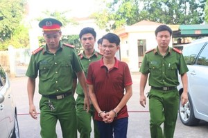 The director who commits tax evasion is escorted by police officers (Photo: SGGP)