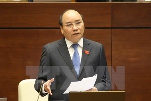 Prime Minister Nguyen Xuan Phuc answers questions at the second working session of the parliament (Photo: VNA)