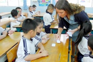Foreign teacher teach Maths to kids in the program (Photo: SGGP)