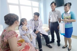 Social workers visit a kid patient to encourage her to overcome the illness (Photo: SGGP)