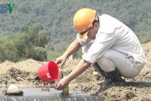 A worker collects water samples at the dam collapse site in the central province of Nghe An. (Photo: vov.vn)