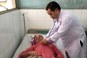 Dr. Nguyen Khac Vui provides first aid to a foreign visistor (Photo: SGGP)