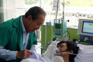 Deputy PM Binh visits a fire victim at Cho Ray Hospital (Photo: SGGP)