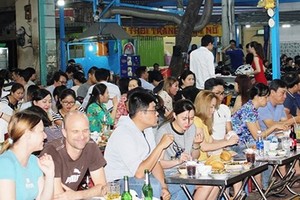People enjoy their dishes in the new food street (Photo: SGGP)