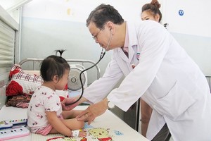 A medical worker is examining a tuberculosis kid in Pham Ngoc Thach hopital (Photo: SGGP)