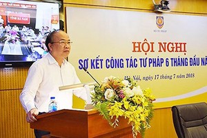 Deputy Minister of Justice Phan Chi Hieu is presenting his report in the meeting