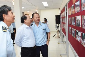Tat Thanh Cang, Standing Deputy Secretary of the municipal Party Committee, looks at pictures featuring customs activities (Photo: SGGP)