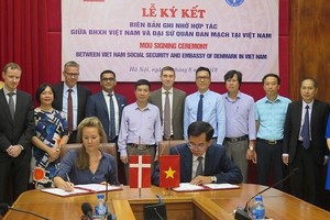 Deputy Ambassador of Denmark Louise Holmsgaard (L) and VSS Deputy General Director Dao Viet Anh sign the MoU on August 21 (Photo: baohiemxahoi.gov.vn)