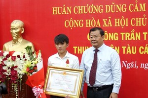  Vice Chairman of the Quang Ngai People's Committee Nguyen Tang Binh (R) presents the Bravery Order to Tran Thanh Ron on November 21 (Photo: VNA)