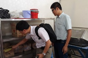 Inspectors check food material at a business (Photo: SGGP)