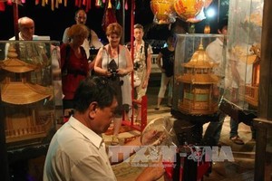 Foreign tourists visit a booth at the previous edition of the craft festival (Photo: VNA)