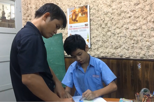 Phan Minh Thong is patiently teaching his students in the Binh Thanh School of Hope for Hearing-impaired People