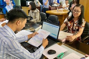 63-year-old Dao Thi Thu ( R) at Van Hien University's office to register at piano and French classes (Photo: SGGP)