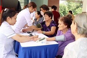 Young medical workers provide checkup to elderly people (Photo: SGGP)