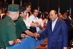 Prime Minister Nguyen Xuan Phuc (R) greets participants in the programme in Hanoi on October 17 (Photo: VNA)