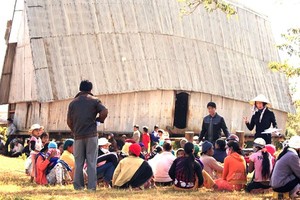 Yuko ( with a conical hat and Vietnamese traditional clothing) talks to residents about safe eating (Photo: SGGP)