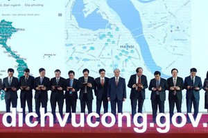 Prime Minister Nguyen Xuan Phuc and other delegates pressed the launching button for the official operation of the National Public Service Portal. (Photo: SGGP)