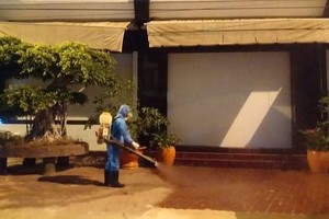 A medical worker sprays disinfectant to clean places the 34th Covid-19 patient droppped by (Photo: SGGP)