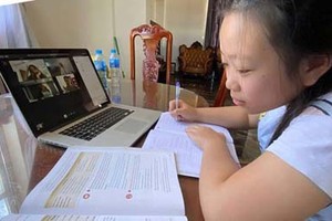 Pham Thuy Hien, a student of Quang Trung Secondary High School, is taking an online lesson at home. (Photo: SGGP)