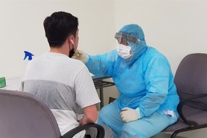 A medical worker checks a passenger’s health when entering Tan Son Nhat International Airport in HCM City. — VNA/VNS