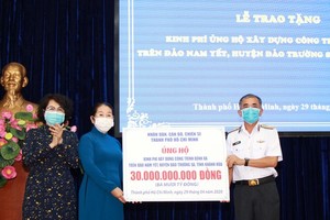 Deputy Secretary of the municipal Party Committee Vo Thi Dung gives support money to Deputy Commander of the Vietnam People's Navy Rear Admiral Luong Viet Hung (Photo: SGGP)