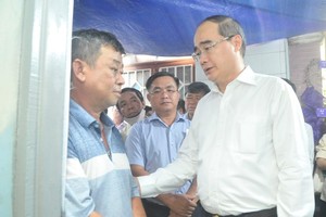 Secretary of the Ho Chi Minh City People’s Committee Nguyen Thien Nhan (1st, R) expresses his condolence to the bereaved father (Photo: SGGP)