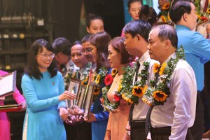 Head of HCMC Federation of Labor Tran Thi Dieu Thuy delivered awards to outstanding laborers in HCMC. (Photo: SGGP)