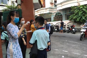 Teachers of Kien Thiet High School in District 3 take students' temperature (Photo: Dan Thuy)