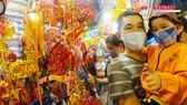 Residents in HCMC with facemasks travel around bustling lantern streets