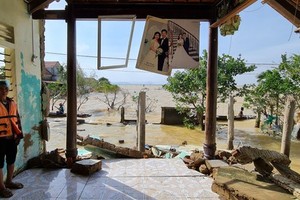A woman in her collapsed house in Quang Binh province, one of the worst hit localities in the long lasting heavy rain and flooding in the Central region (Photo: SGGP)