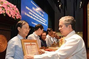 Deputy Chairman of the city People's Committee Ngo Minh Chau presents certificates of merit to administrators in districts which carried out good administrative reform programs (Photo: SGGP)