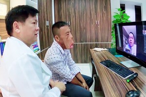 Dr. Nguyen Phan Tu Dung  and patient Le Van Men (Photo: SGGP)